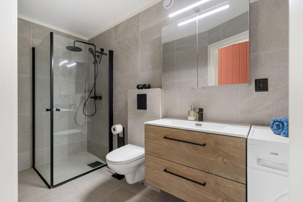 Contemporary bathroom with a wood vanity and frameless glass shower enclosure
